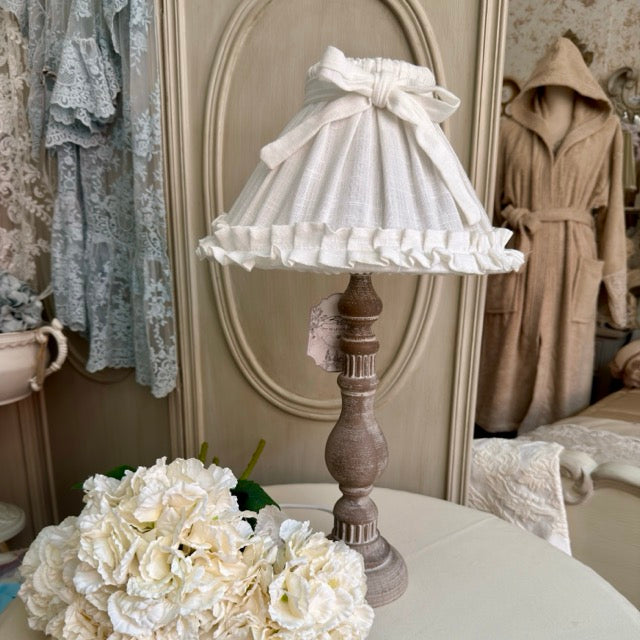 Lampada da tavolo in legno tornito anticato con paralume in lino naturale e volant
Blanc Mariclò – Sweet Home Shabby Style
Vista frontale, sfondo neutro